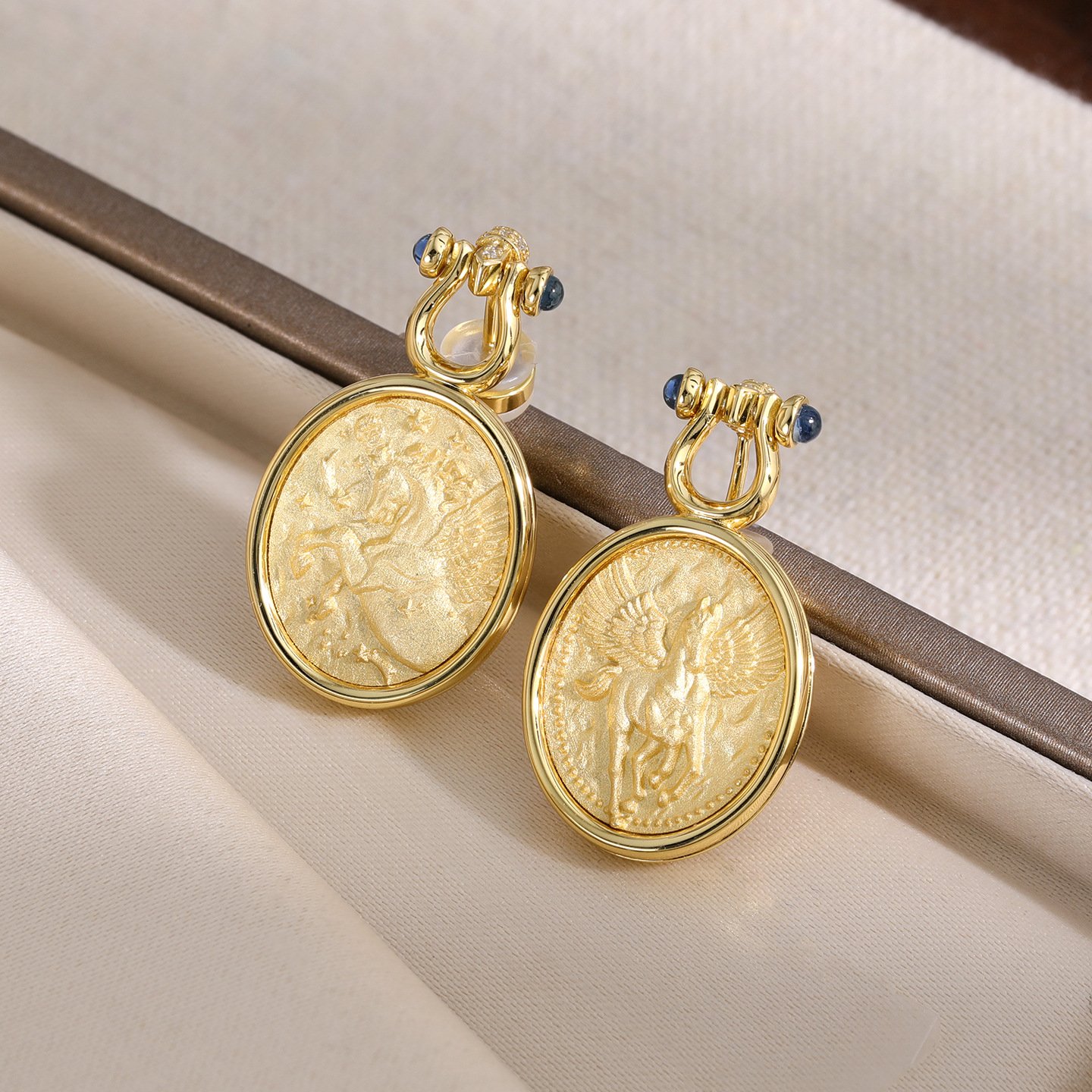 sandoos-aac30961c62e44df498c91633689443d5826a97427eca55c8b2dd2af79a0a0ad Gilded Pegasus Coin Stud Earrings